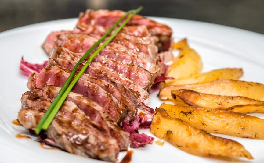 Albergo Panorama *** © Albergo Panorama Gegrilltes Steak in Scheiben mit Kräuterkartoffeln auf weißem Teller