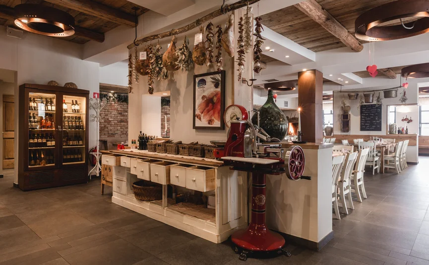 Rustic restaurant interior with hanging dried goods and wine display