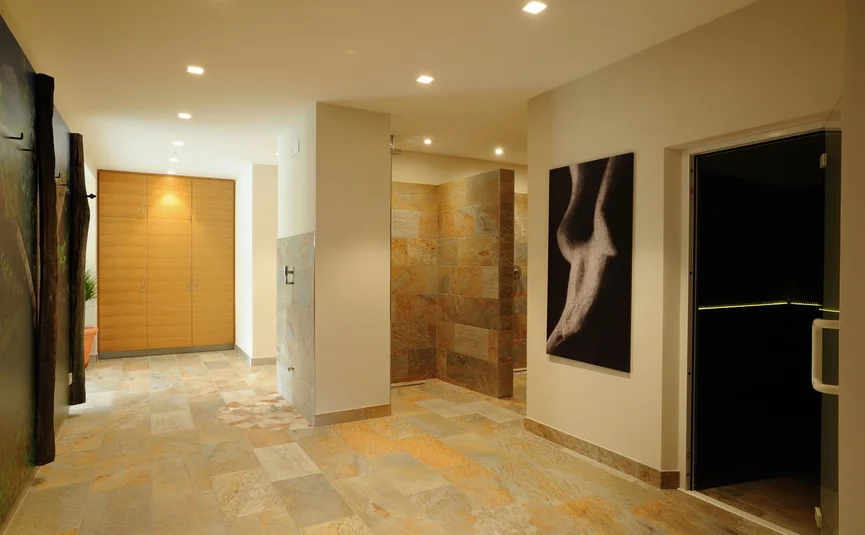 Modern wellness area with beige tiles and wooden cabinet