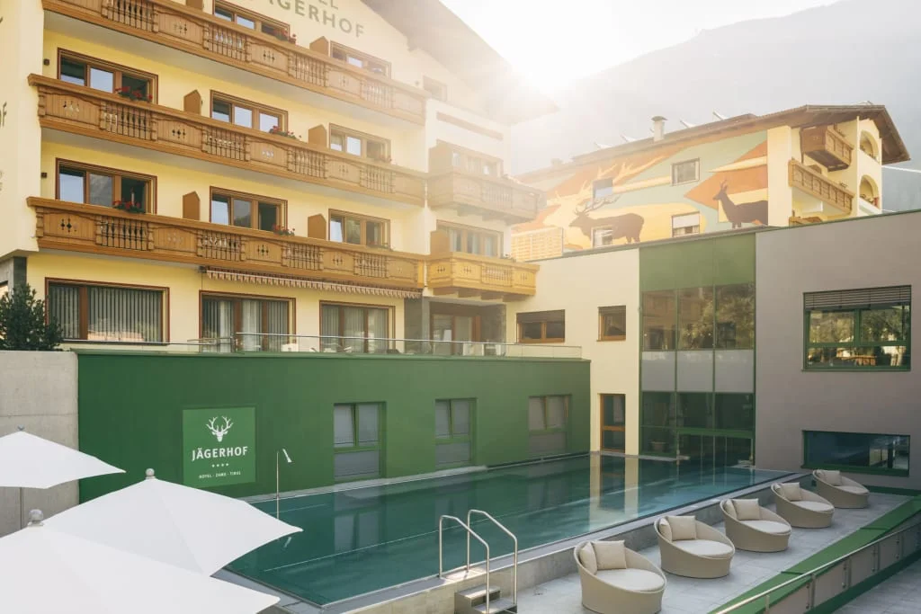 Verwöhnzeit Deluxe | ab 3 Nächte Teilmassage inkludiert Hotel Jägerhof met buitenzwembad en zithoek in zonlicht