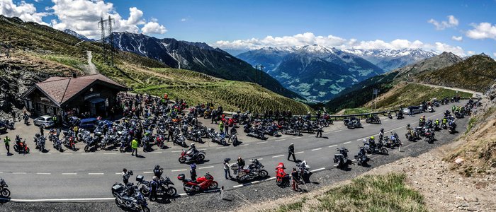 Motorradurlaub im Trentino © Gianni Rodorigo Motorradfahrer versammeln sich an einem Bergpass mit Alpenpanorama