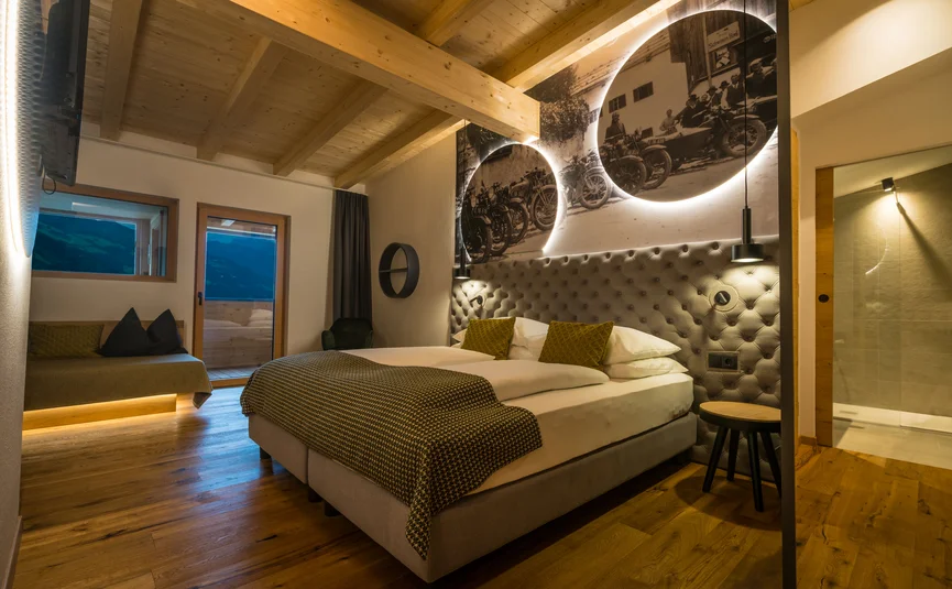 Cozy hotel bedroom with wooden floor and illuminated vintage motorcycle artwork