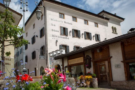 Historisch hotel en restaurant La Stua met bloemen op de voorgrond