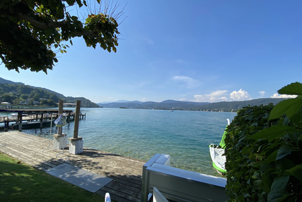 Seentour - vor der Haustür liegt das Glück See mit Steg, grünem Ufer und Bergen bei klarem Himmel