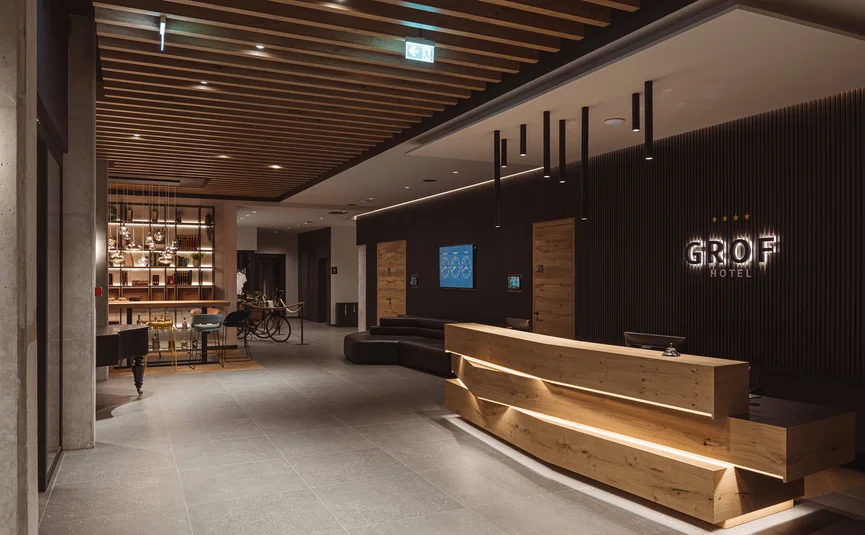 Modern hotel lobby with wooden reception desk and ambient lighting