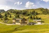 Sammelanfragen © Alexander Seger Hotel in grüner Berglandschaft mit Sessellift und Traktor im Vordergrund