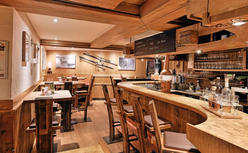 Cozy wooden bar with high chairs and ski decorations on the wall