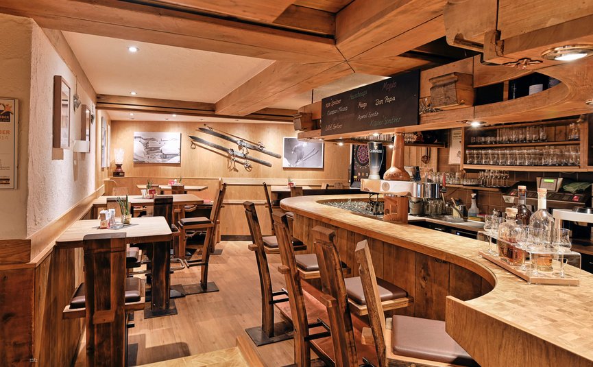 Haus Flexen © Mathies Wilhelm Robert jun. Gemütliche Holzbar mit hohen Stühlen und Skidekoration an der Wand