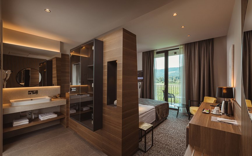 Modernes Hotelzimmer mit Holzakzenten und Balkon mit Ausblick