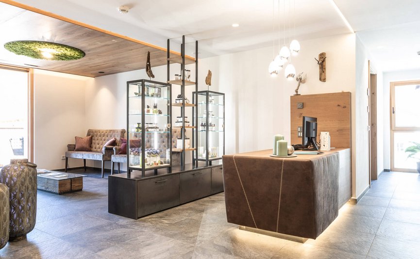 Motorrad- & Spa Hotel Traube Post am Reschensee **** © Theiner Karl-Heinz & Co KG Helles modernes Wartezimmer mit Empfangstheke und Vitrinen