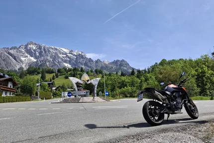 Motorcycle at roundabout with mountain scenery and clear blue sky