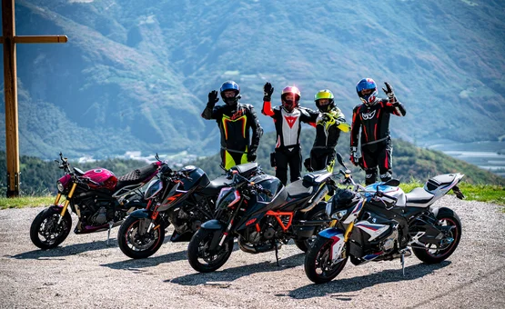 Vier Motorradfahrer mit ihren Motorrädern vor Bergkulisse