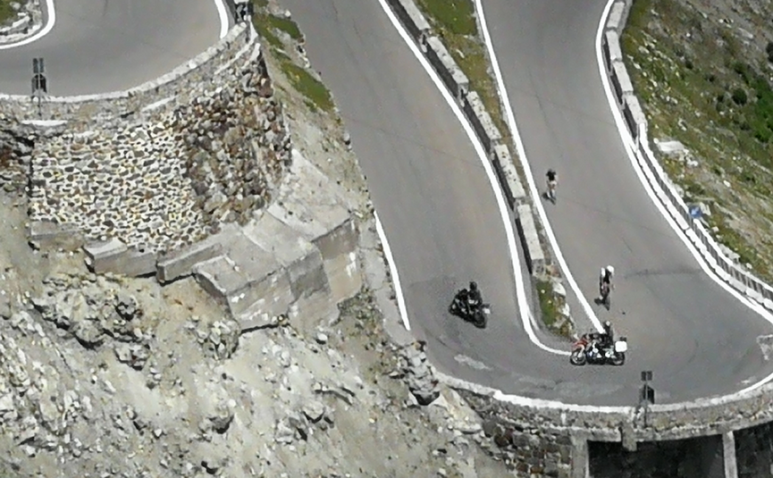 MoHo Schönauer Hof Tour Stelvio Variant 3 Livigno Hairpin turns on mountain road with motorcycles and cyclists