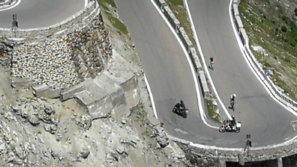 Haarnadelkurven auf Bergstraße mit Motorrädern und Radfahrern