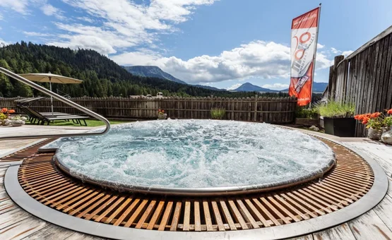 Sprudelnder Whirlpool auf Holzterrasse mit Bergblick