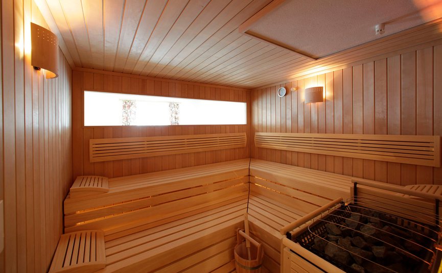 Holzsauna mit Bänken, Beleuchtung und Ofen mit Steinen