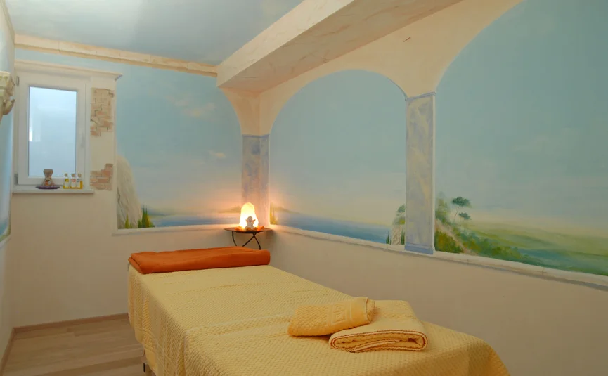 Treatment room with massage table and calming mural