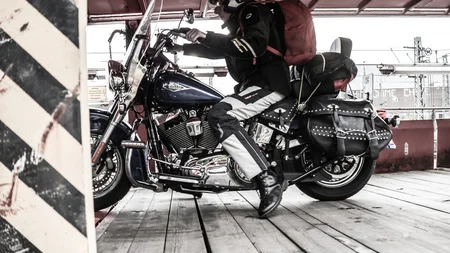 Motorradfahrer mit Helm und Rucksack auf Harley Davidson Motorrad