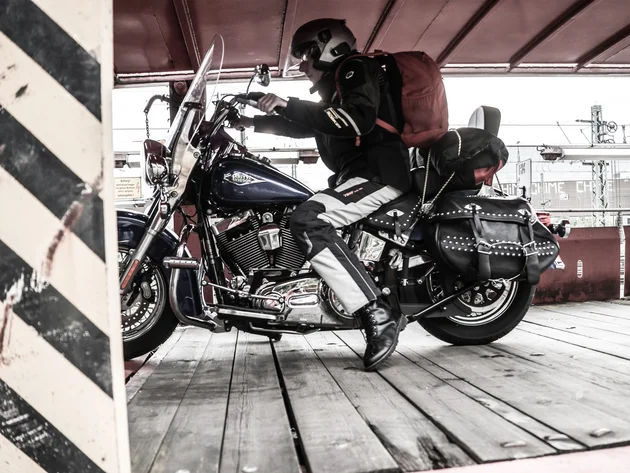Motorradfahrer mit Helm und Rucksack auf Harley Davidson Motorrad