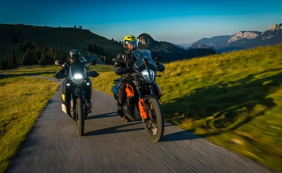 KTM Friends Tour Two motorcyclists riding on mountain road in sunny clear weather