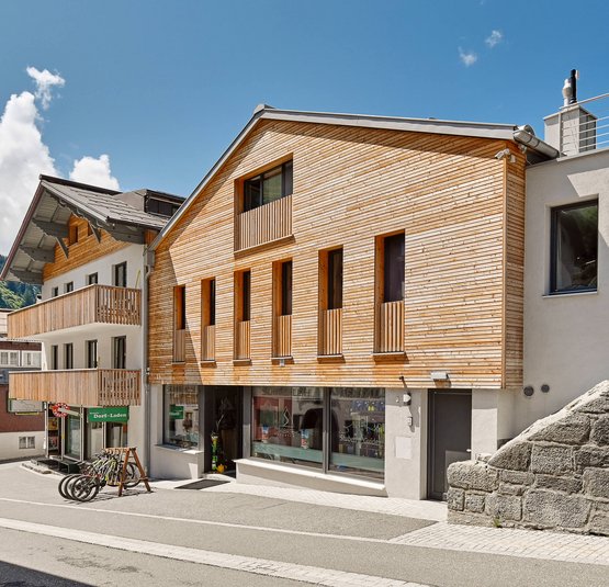 3-Länder-Tourentraum © Mathies Wilhelm Robert jun. Straße mit modernen Häusern aus Holz und Stein unter blauem Himmel