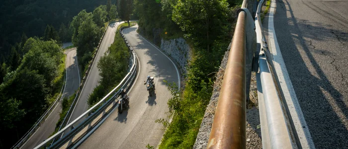 Kronkelende bergweg met twee motoren en groene bomen