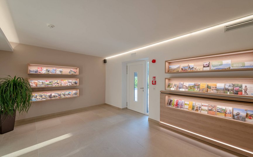 Moderne Touristeninformationslobby mit beleuchteten Broschürenregalen