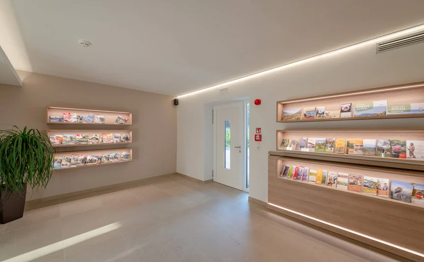 Modern tourist info lobby with illuminated brochure displays