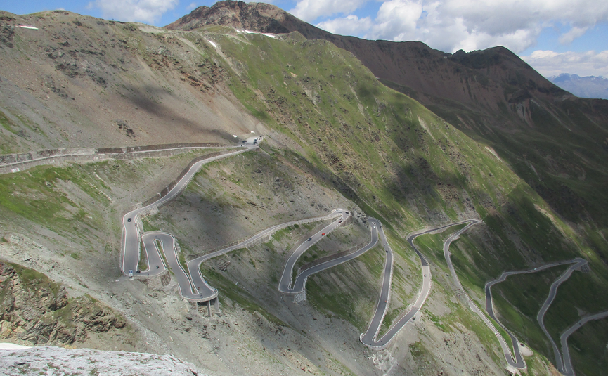 MoHo Schönauer Hof- Tour 12 Stilfserjoch Umbrail Mountain road with sharp hairpin turns under blue sky