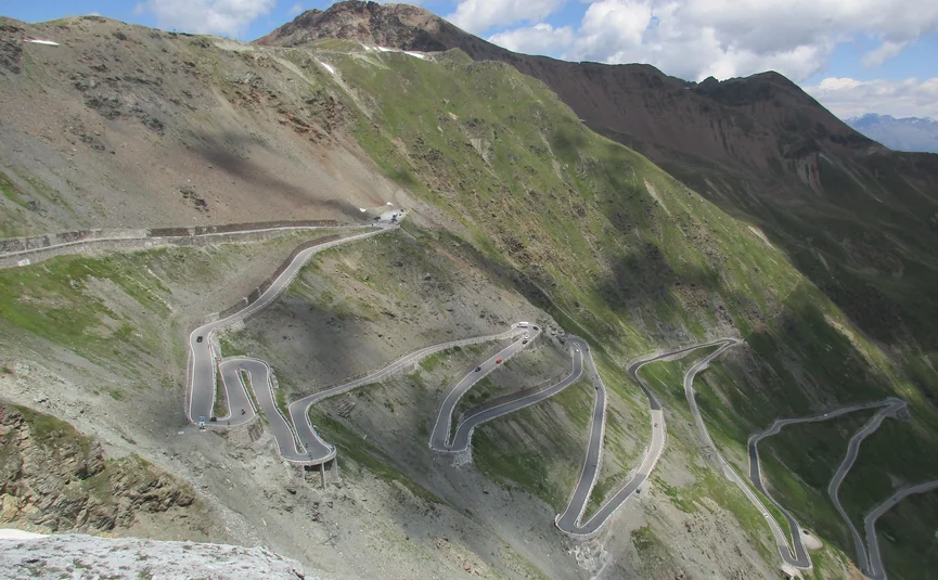 Mountain road with sharp hairpin turns under blue sky