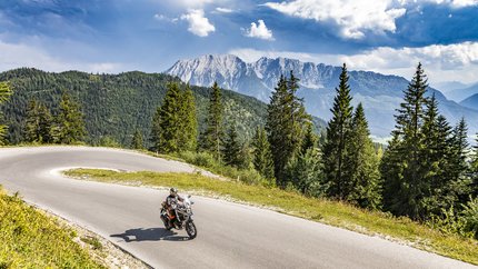 Steiermark © Alexander Seger Motorradfahrer auf kurviger Bergstraße mit Tannen und Bergen im Hintergrund