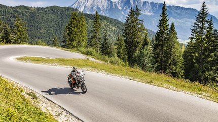 Obersteiermark – Ausseerland – Salzkammergut © Alexander Seger Motorradfahrer auf kurviger Bergstraße mit Tannen und Bergen im Hintergrund