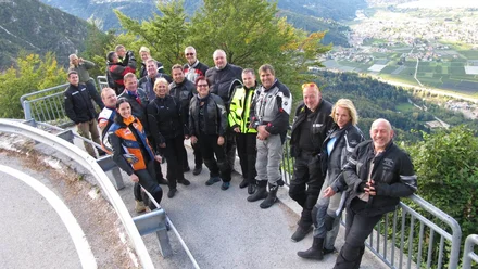 Geschichte der MoHo's Gruppe von Motorradfahrern auf Bergstraße mit Talblick