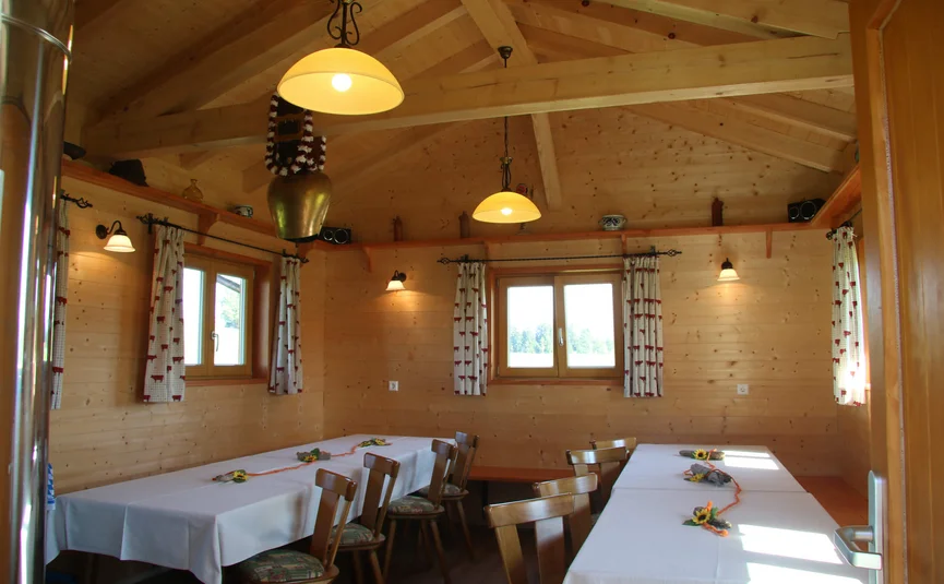Wooden room with white tablecloths and wooden chairs