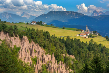 Mendelpass - Ulten Landschaft mit Erdpyramiden, Wäldern, grünen Wiesen und Bergdorf im Hintergrund