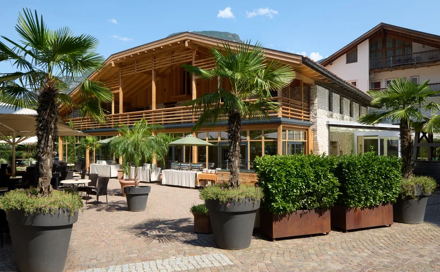Hotel Teutschhaus ***S © Fotostudio Eheim Holz- und Steinhaus mit Terrasse, Palmen und Sitzplätzen im Freien