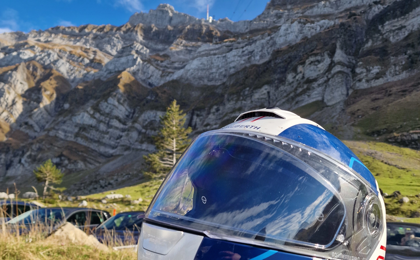 MoHo Schönauer Hof tour 11 Schwägalp Motorcycle helmet with mountain landscape under blue sky and clouds