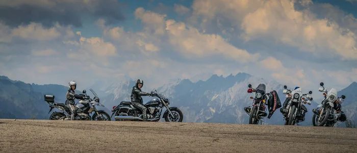 Friuli - Carnia © Moppetfoto.de Motorrijders met motoren voor bergen onder bewolkte lucht