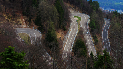 Serpentinenstraße mit scharfen Kurven in bewaldetem Berggebiet
