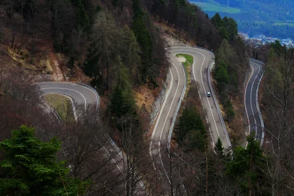 Winding mountain road with sharp hairpin turns surrounded by forest