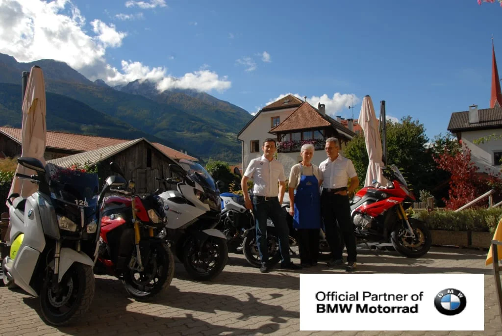 Freiheit auf zwei Rädern Drie personen voor BMW motorfietsen in een berglandschap