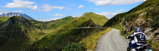 Motorradurlaub in Friaul – Karnien © Hotel Ristorante Bellavista Motorradfahrer auf Bergstraße mit grünen Hügeln und blauem Himmel
