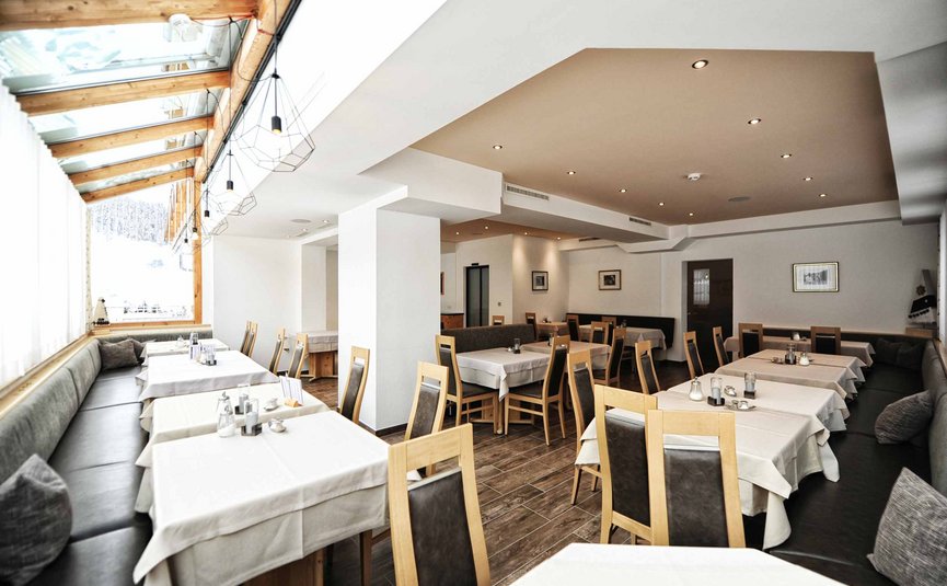 Lege moderne eetkamer met houten stoelen en witte tafelkleden.