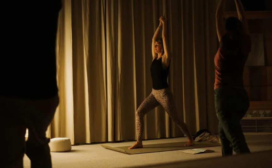 Personen praktizieren Yoga in einem gedämpften, entspannten Raum