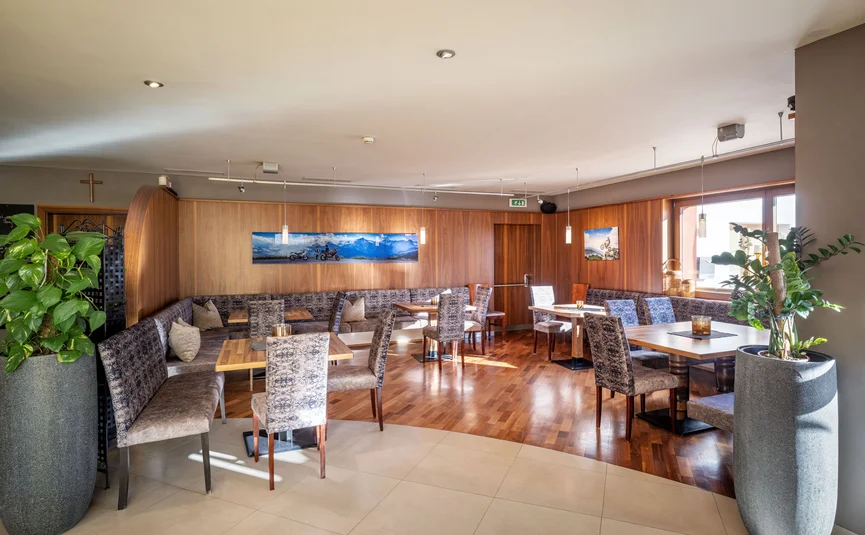 Bright modern dining area with wooden floors and upholstered seating