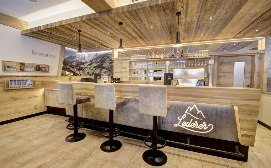Modern hotel reception area with bar and high stools