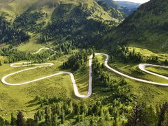 Winding mountain road through green hills and forest