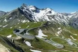 Großglockner tour Winding mountain road with patches of snow under a clear blue sky