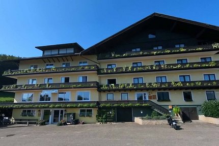 Gast-Hof-Laden Schneeweiss © Gast-Hof-Laden Schneeweiss Großes uriges Chalet mit Balkonpflanzen bei klarem Himmel