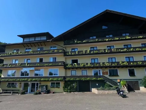 Gast-Hof-Laden Schneeweiss © Gast-Hof-Laden Schneeweiss Großes uriges Chalet mit Balkonpflanzen bei klarem Himmel